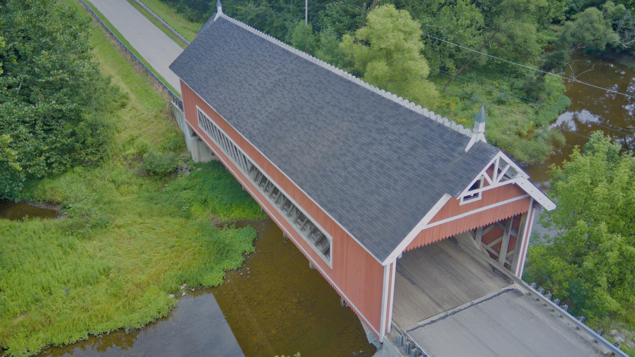 Elevated aerial view of Netcher Road covered bridge over a wooded creek